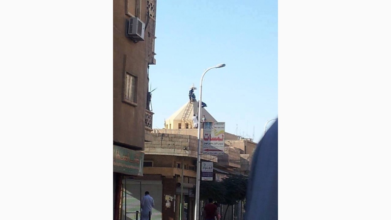 علم داعش يرفرف على كنيسة بعد حرقها في الرقة