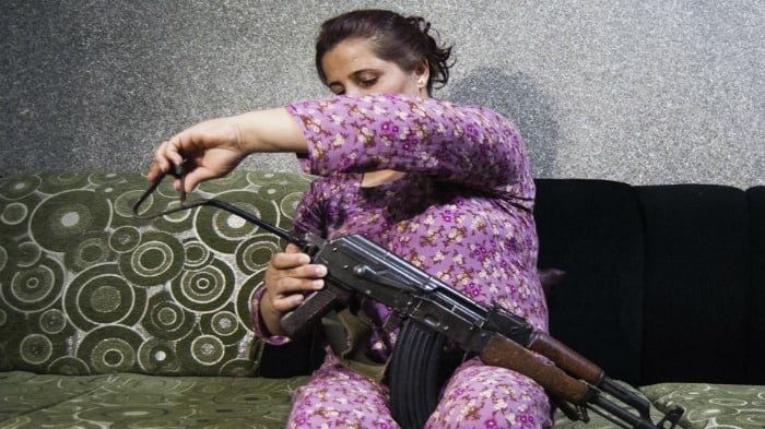 Syrian woman trained to use a Kalashnikov rifle to protect her five children
